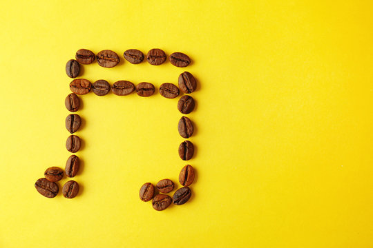 Musical note made of coffee beans on yellow background