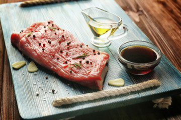 Delicious steak smearing with aromatic garlic and pepper on wooden board