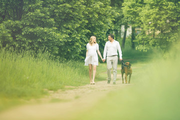 Fototapeta premium happy couple future parents on the walk with the dog in the Park