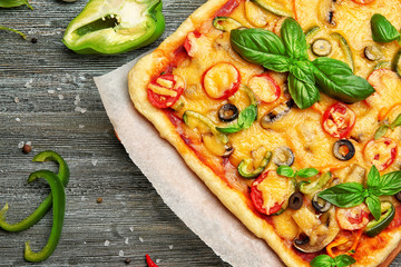 Delicious pizza with ingredients on wooden background