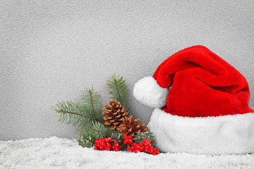 Obraz na płótnie Canvas Santa Claus hat with Christmas decoration on gray textured background