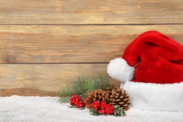 Obraz na płótnie Canvas Santa Claus hat with Christmas decoration on wooden background
