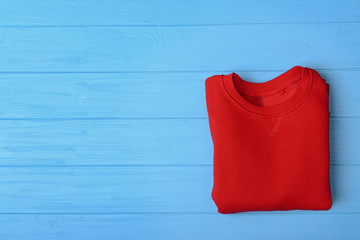 Red sweater on blue wooden background