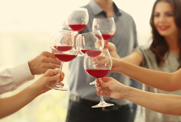 People toasting with glasses of red wine, closeup