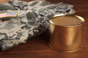 Uniform of American soldier and combat ration on wooden background, close up view