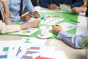 Cup of coffee on the desk during business team work in the office