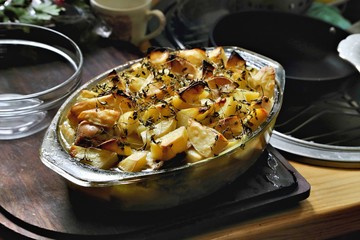 Cottage pie with potatoes and meat, presented on wooden board.