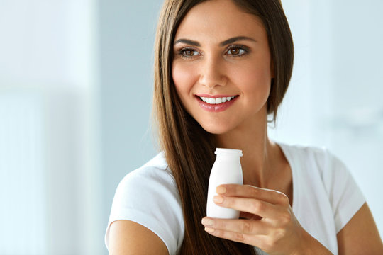 Diet Nutrition. Beautiful Smiling Woman Drinking Yoghurt Indoors