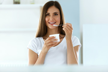 Beautiful Woman Eating Organic Yogurt. Healthy Diet Nutrition