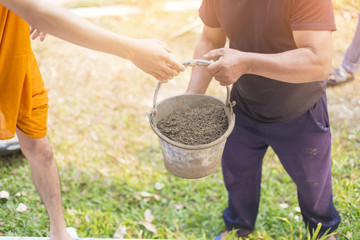 Older Labor or workers carrying construction sand for mix with cement and building houses. Two men are working on a construction site