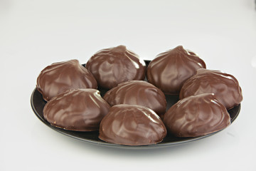Delicious chocolate marshmallow on plate on white