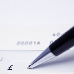 Pen writing a cheque in British Pounds Sterling 