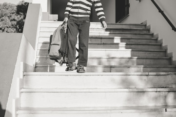 Back view of boy walking on stairs outdoors building background