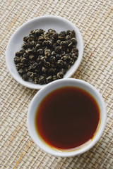 Teacup with tea and plate with tea leaves