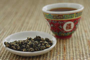 Tea leaves on plate with Chinese teacup