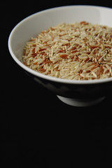 Bowl of uncooked rice against black background