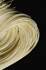 Chinese noodles against black background, close up