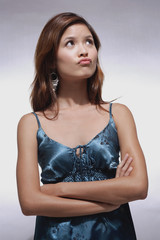 Woman in blue top, arms crossed, making a face