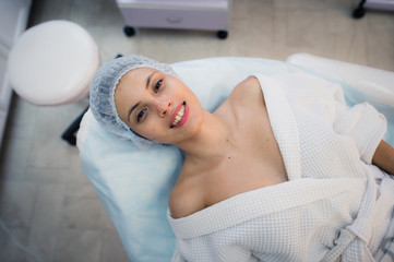 Fototapeta na wymiar Top view of beautiful young woman getting ready for face skin treatment, lying on bed at hospital or clinic