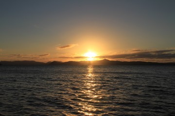 Sunrise over the Whitsunday Islands QLD Australia with reflections of the sun on the water