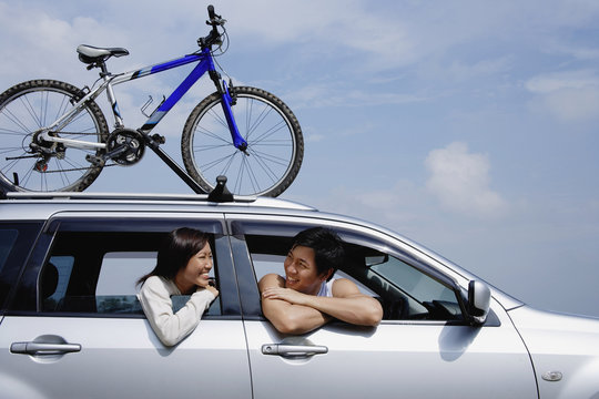Couple Sitting In Car, Leaning Out Of The Windows, Bicycle On The Roof