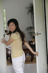 Fototapeta na wymiar Woman walking through doorway at home, looking over shoulder