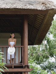 Young woman standing in balcony, smiling © Alexander