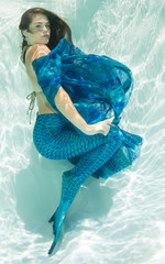 Mermaid swimming in a pool underwater.