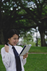 Young woman in school uniform, reading a book