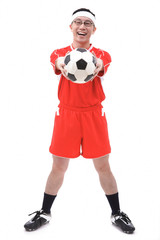Man in soccer uniform holding soccer ball towards camera