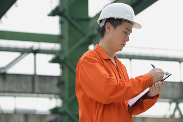 Construction worker making notes on clipboard