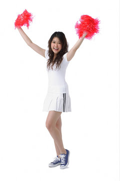 Young woman cheerleading with pom poms