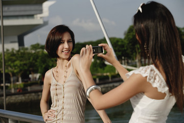 Friends take photos of each other on a bridge