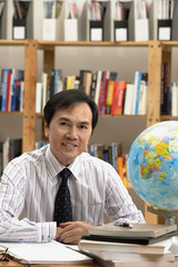 A man working with a globe on the desk