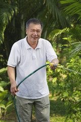 Man with hose, watering garden