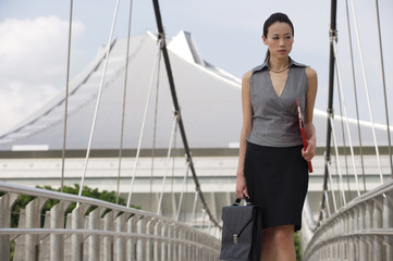 Businesswoman walking while looking into distance