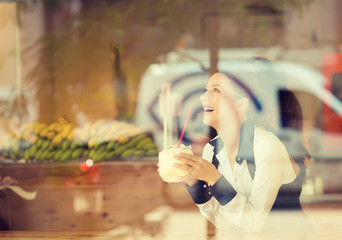 Woman at trendy juice bar coffee shop. Young model enjoying lunch