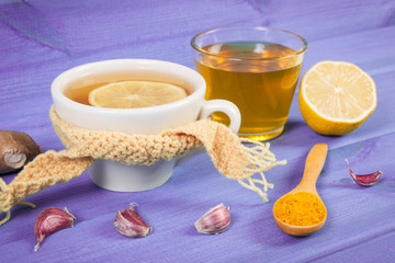 Cup of tea with lemon and ingredients for preparation warming beverage