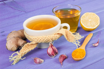Cup of tea with lemon and ingredients for preparation warming beverage