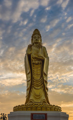 Golden Guanyin statue Buddha with Twilight sky background.