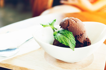 Close up chocolate ice cream and herbs with leaves mint in cafe