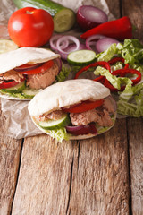 Healthy sandwich: pita with tuna, cucumber, nappa cabbage, onions, peppers and tomatoes close-up