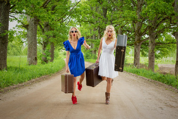 Two women runing with suitecases in their hands