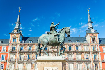 Naklejka na ściany i meble Felipe III statue and Casa de la Panaderia on Plaza Mayor in Madrid, Spain