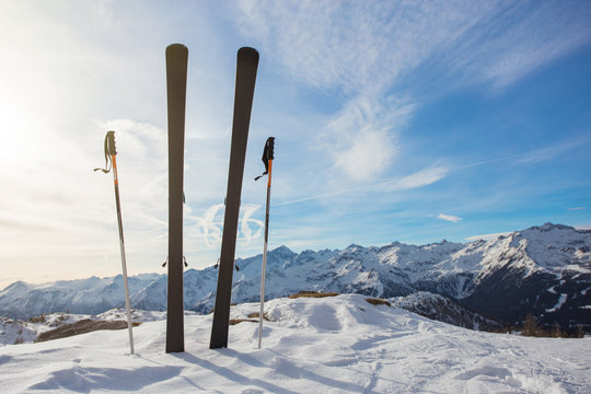Skis in mountains against blue sky
