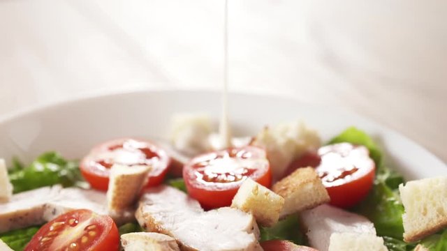 caesar salad closeup handheld follow dressing pour into salad