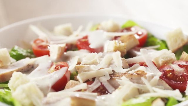 caesar salad closeup handheld pan over prepared dish