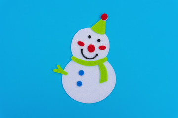 flat smiling toy christmas snowman with green scarf on blue