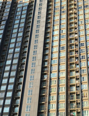 Fototapeta premium Perspective and underside angle view to textured background of modern glass building skyscrapers over blue cloudy sky