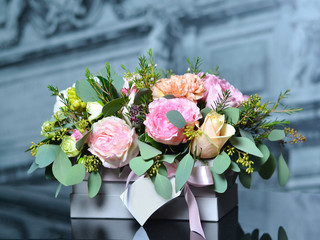 Bouquet with beige roses and pink peonies in a gray box